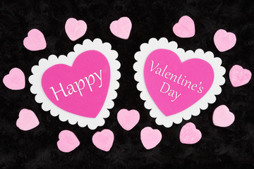 Happy Valentine's Day greeting with white and pink hearts and candy hearts on black