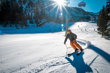 Young skier turning on a slope during a sunny day 