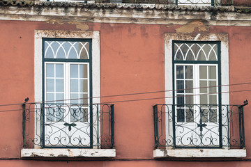 Windows with decorative balconies, traditional architecturial style in downtown Lisbon Portugal. Orange wall