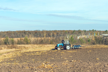 Obraz premium The tractor plows a field, cultivates the soil for sowing grain