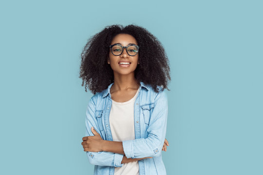 Freestyle. African girl wearing glasses standing isolated on gray crossed arms smiling sassy close-up
