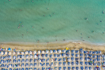 Aerial top view on the sandy beach. Umbrellas, sand and sea waves landscape.