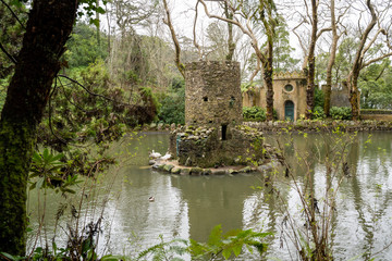 Fototapeta na wymiar Ancient duck houses resembling a tower or castle at Pena Palace gardens in the Valley of Lakes area of Sintra Portugal