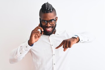 African american businessman talking on smartphone over isolated white background with surprise face pointing finger to himself