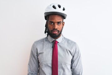 Fototapeta premium African american businessman with braids wearing bike helmet over isolated white background with serious expression on face. Simple and natural looking at the camera.
