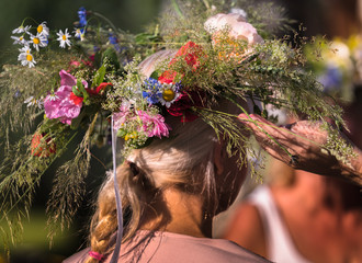 Naklejka premium summer solstice wreath on head, handmade, individual parts in focus, summer day