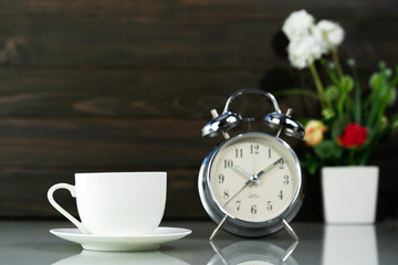 Fototapeta na wymiar Coffee cup and alarm clock on table