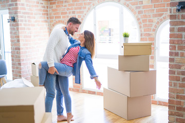 Young beautiful couple dancing  at new home around cardboard boxes