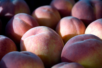 A group of ripe peaches in a bowl