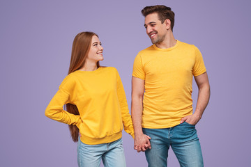 Happy couple in similar clothes holding hands