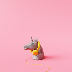Concrete unicorn statue with headphone on pastel pink background. Creative idea. Minimal concept. 3d rendering