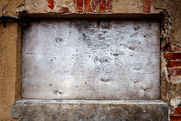 Boarded up window on old wall
