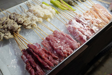 Thai street food: All kind of uncooked food in sticks.