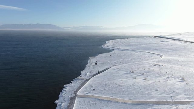Aerial View of China Xinjiang Sayram Lake(sailimu hu) in winter. Climate and travel concept. Drone Shot Footage 4K (UHD).