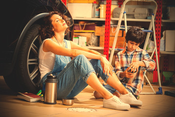 Fototapeta na wymiar resting mechanic woman and boy with thermos