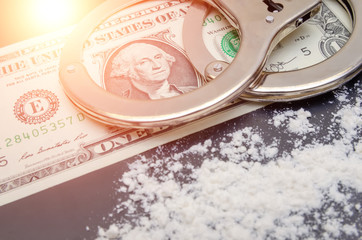 Handcuffs, money and cocaine drugs on black background close up