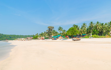 Beautiful beach view with fishing boat, yellow sand and blue ocean, Goa state in India
