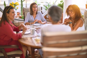 Young beautiful girl smiling happy and confident sitting dinking cup of coffee at terrace