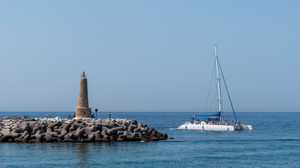 marbella marina with a catamaran an a small lighthouseon the sea, spain