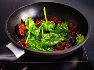 OLYMPUS DIGITAL CAMERASun dried tomatoes fried with spinach in cooking pan