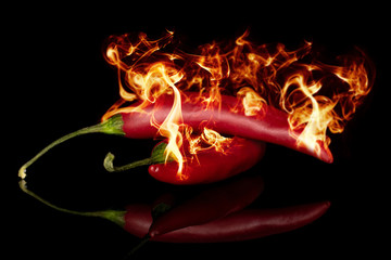 Red hot cayenne chili isolated on black glass