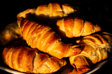 Croissants on a dark background. A delicious mouth-watering breakfast.