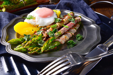 delicious green asparagus wrapped in bacon and egg