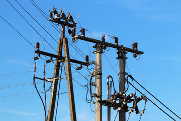 A high-voltage power line illuminated by sunlight against a background of clouds of a stormy sky. Transport of energy over long distances. High technology of modernity.Power industry. Ecology