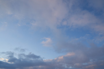 Fototapeta na wymiar Beautiful evening blue sky at sunset with flaming bright light clouds