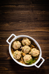 Roasted meatballs in mushroom sauce on wooden table