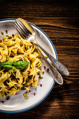 Tagliatelle with with pesto sauce on wooden table