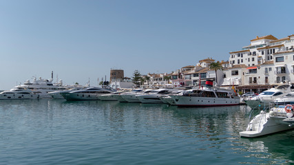 Fototapeta premium marbella marina cityscape on a sunny day with houses, boats and the sea, spain
