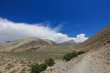 Brown mountains against the blue sky with white clouds