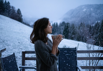 Pensive woman looking at a cold mountain landscape on a winter morning
