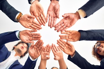 Group of business workers smiling happy and confident. Standing on a circle with smile on face doing symbol with hands together at the office.