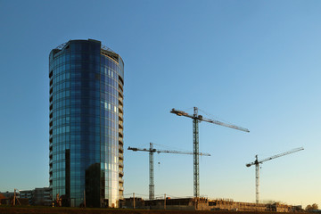 Rzeszow, Poland - oct 8 2018: Modern residential apartment building in the evening sunset. Urbanization and construction in the city. High technology interesting design. The use of tower cranes