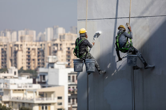 Construction workers painting a building in Noida, Uttar Prades, India