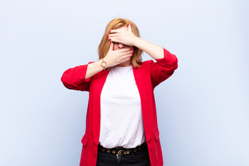 middle age woman covering face with both hands saying no to the camera! refusing pictures or...