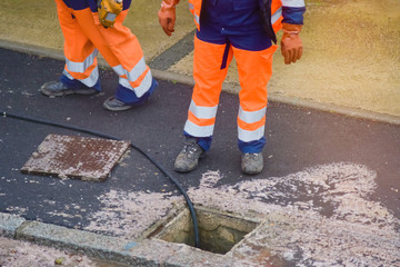workers cleaning and maintaining the sewers on the roads