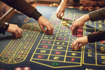 A hand with chips makes a bet on roulette in a casino.