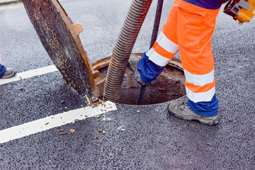 workers cleaning and maintaining the sewers on the roads - 318257158