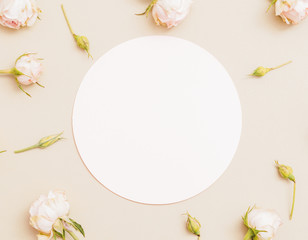 Greeting card mockup. Women day congratulation. White circle roses decor on pale peach background.