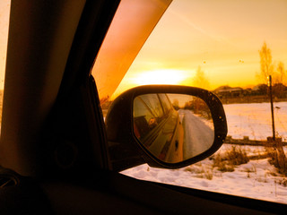 Car mirror at dawn in the winter.