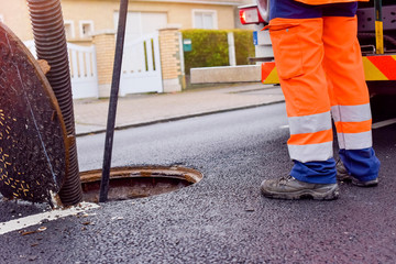 workers cleaning and maintaining the sewers on the roads - 318258364