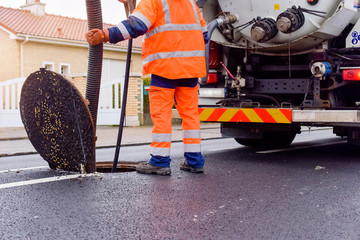 workers cleaning and maintaining the sewers on the roads - 318258371