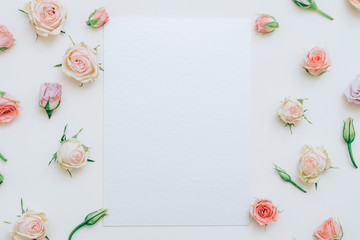 Greeting card mockup. Holiday congratulation. White empty paper on multicolor rose bud pattern background.