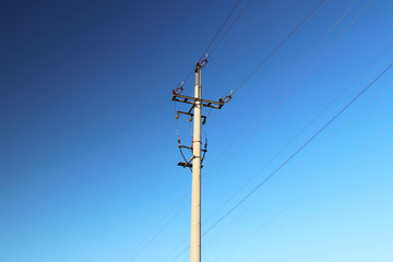 Obraz premium Electrical network of high voltage. Transportation of electricity through the high-voltage line. Metal tower with wires and cables. Clean country energy. Energy security. Work at height. Training matt