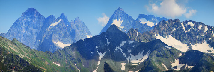 Panorama Caucasus Mountains. Sharp peaks, snow on the slopes. Traveling in the mountains, climbing.