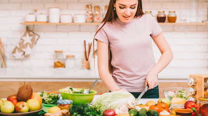 Cooking hobby. Healthy nutrition. Woman making salad with fresh organic ingredients at home kitchen.
