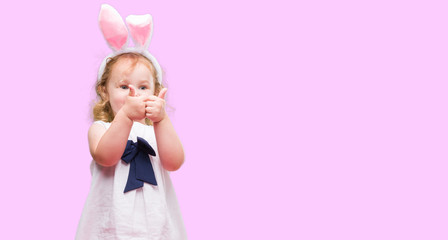 Lovely blonde toddler wearing easter bunny ears